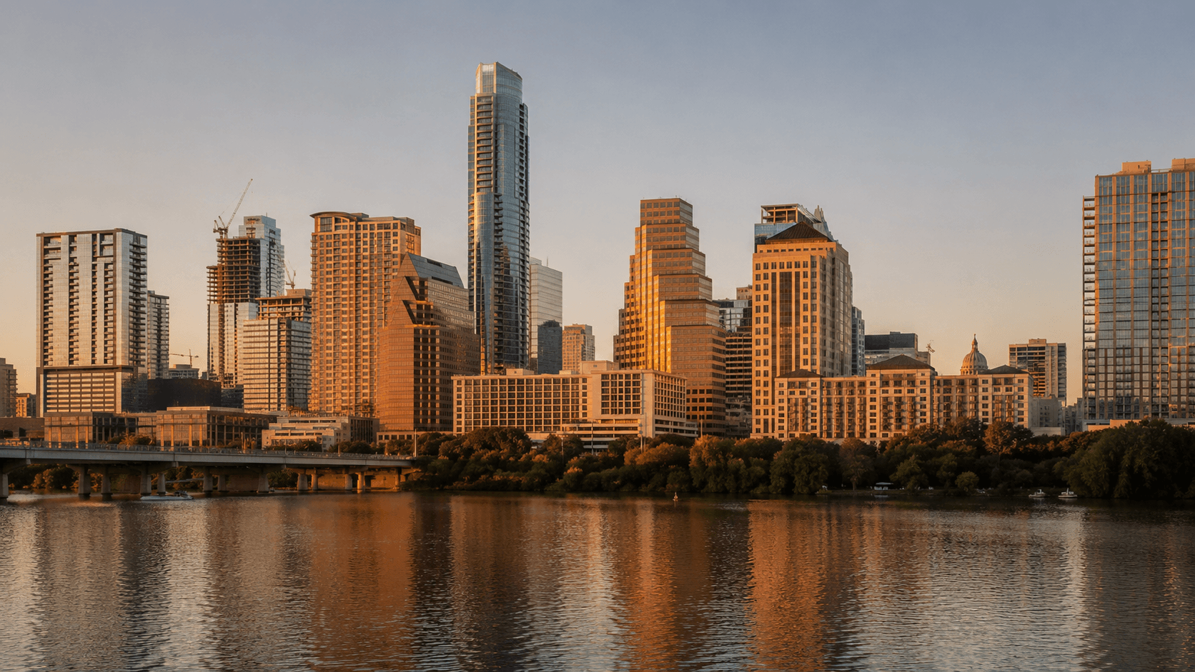 Downtown Austin skyline rising above Lady Bird Lake at golden hour, with the Pennybacker Bridge and Hill Country in the distance